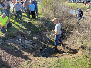 Workers with shovels repair streamside buffer area